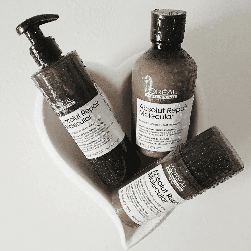 Three L'Oréal Professional Absolut Repair Molecular hair care products in a heart-shaped dish.